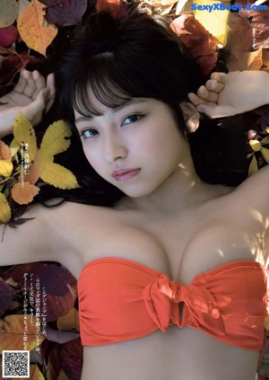 A woman in a blue and black bikini posing for a picture.