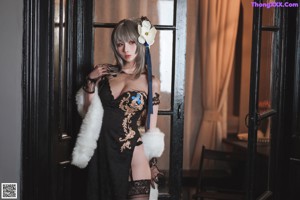 A woman in a black lingerie sitting on a chair.