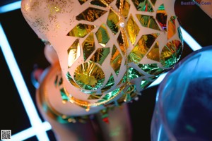 A woman in a gold bikini standing on a stage.