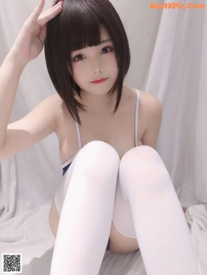 A woman in a blue bodysuit and white stockings posing for a picture.