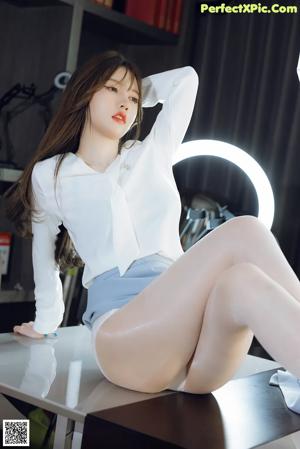 A woman sitting on top of a table next to a mirror.