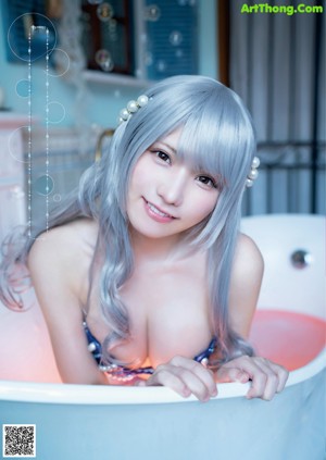 A woman with long gray hair in a bathtub.