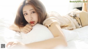 A woman sitting on top of a bed in lingerie.