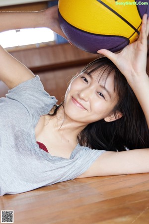 A woman in a blue lingerie sitting on a bed.