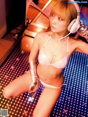 A woman in lingerie sitting in the driver's seat of a car.