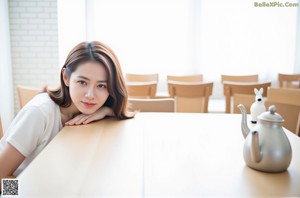 A naked asian woman sitting on a white couch.