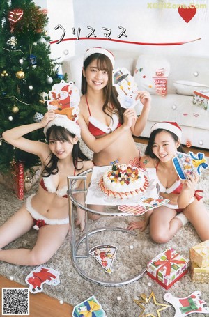 A group of three women in bikinis sitting next to a Christmas tree.