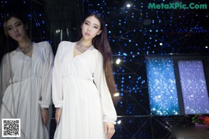 A woman in a white dress posing for a picture.