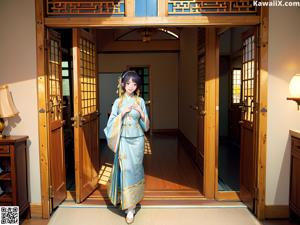 A woman in a kimono is posing on a bed.