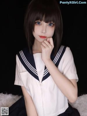 A woman in a sailor outfit is posing for a picture.