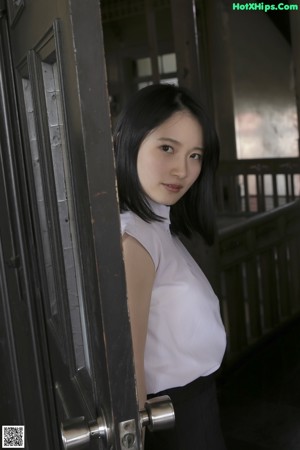 A woman sitting on the ground in front of a window.