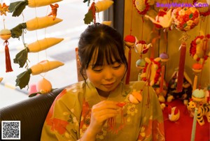 A woman in a kimono sitting on a tatami mat.