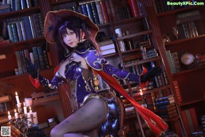A woman in a witch costume sitting on a chair.