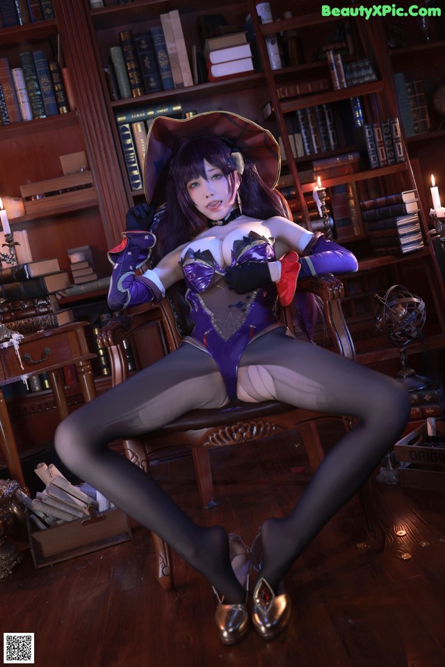 A woman sitting on a chair in front of a bookshelf.