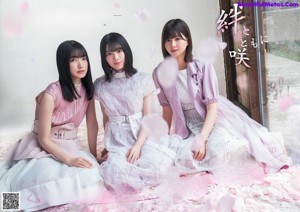 A group of young women sitting on top of a bed.