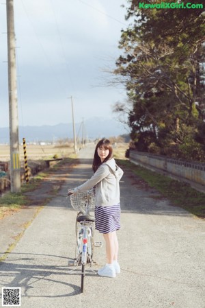 A woman in a school uniform leaning against a railing.